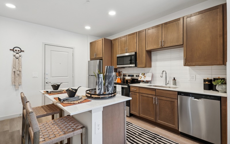 Kitchen with island, custom cabinetry, and stainless steel appliances