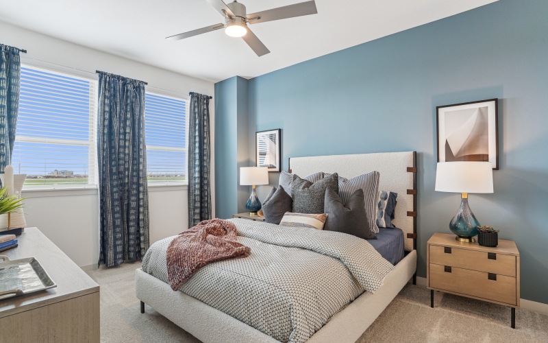 Spacious bedroom with ceiling fan and carpet
